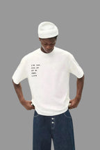 Person wearing a white t-shirt with text and blue jeans on a plain background, featuring the ASOS logo.