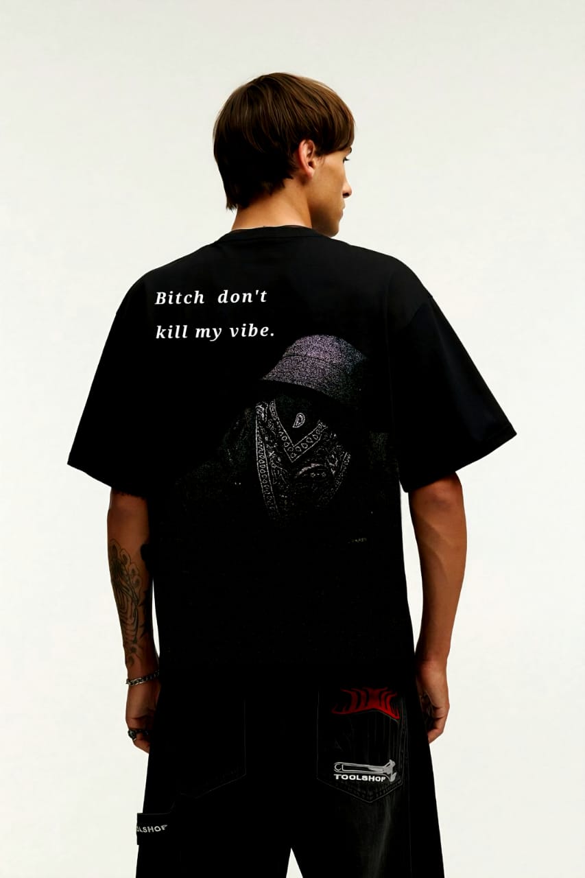Person wearing a black t-shirt with text and graphics on the back, standing against a white background.