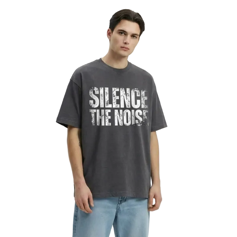 Person wearing a dark gray t-shirt with 'Silence the Noise' text on a light gray background