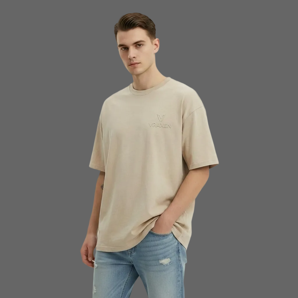 Man wearing a beige t-shirt and light blue jeans on a white background